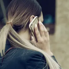 Kobieta z blond kucykiem rozmawia przez telefon, zastanawiając się, czy można odmówić urlopu na żądanie.