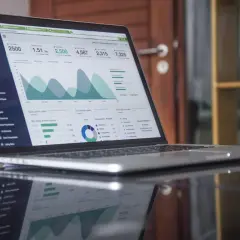 Na ekranie laptopa widoczny jest pulpit menedżerski z wykresami i danymi, przypominający rejestr akcjonariuszy prostej spółki akcyjnej.