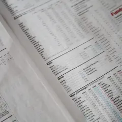 Gazeta finansowa z wykresami i tabelami, zawierająca m.in. ceny akcji i kursy walut. Widać nagłówki takie jak "Rates", "Money", "Major price changes FTSE 100 Week on week", a także przykłady cen transferowych.