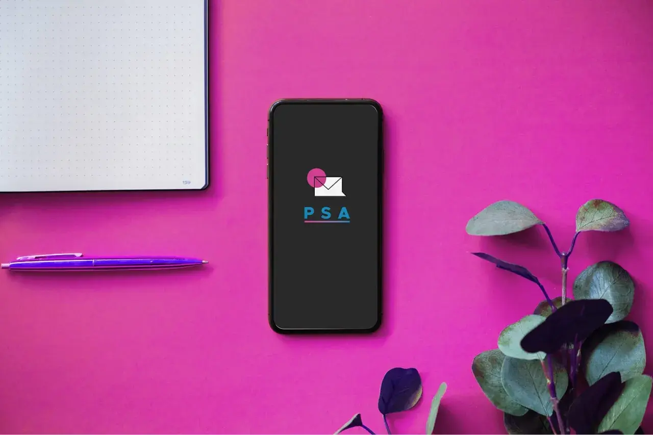 Telefon z logo PSA, notatnik i fioletowy długopis. Idealne narzędzia do założenia prostej spółki akcyjnej.