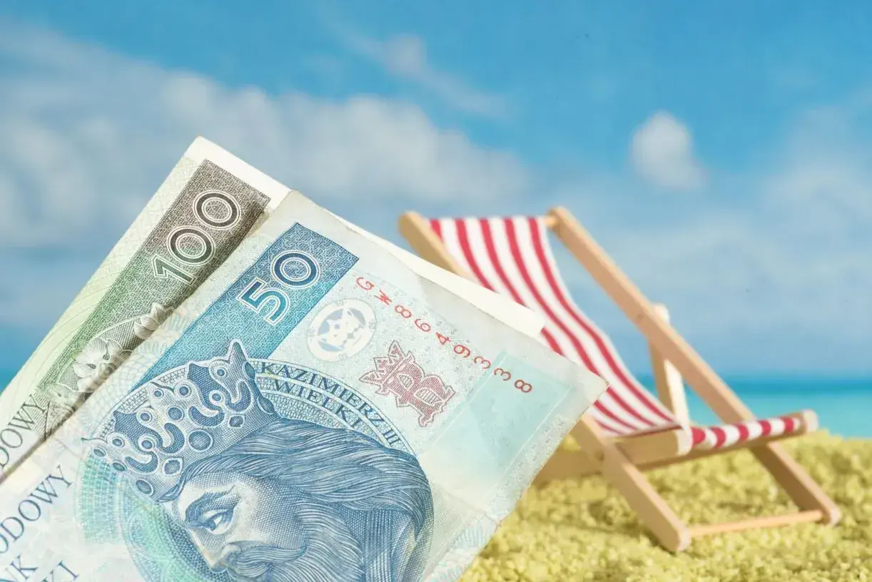 Pieniądze na plaży, leżak i błękitne niebo. To może być Twoje świadczenie urlopowe 2026!